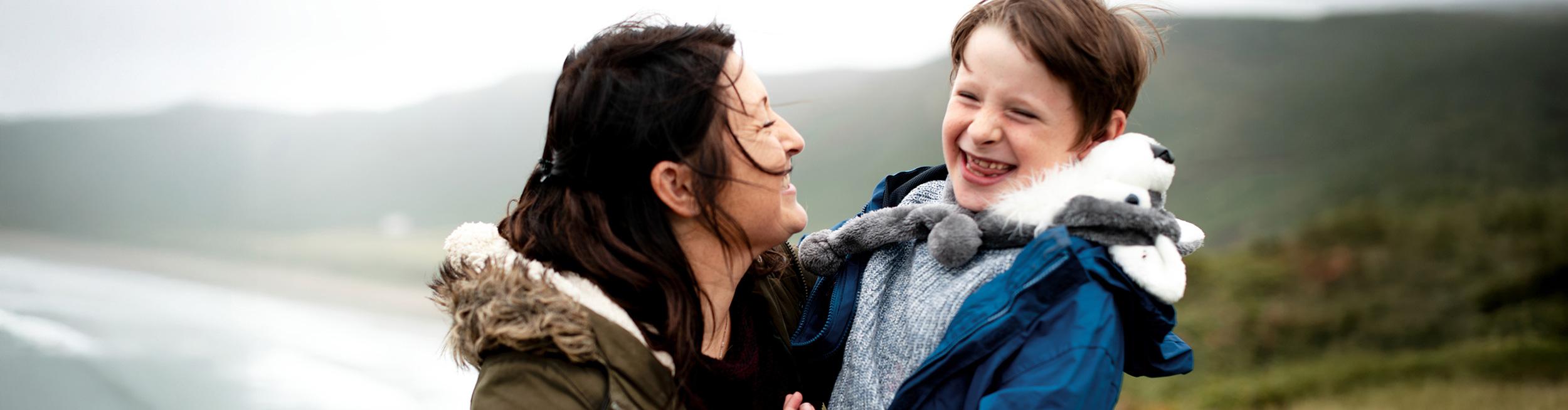 A woman and a boy smiling together