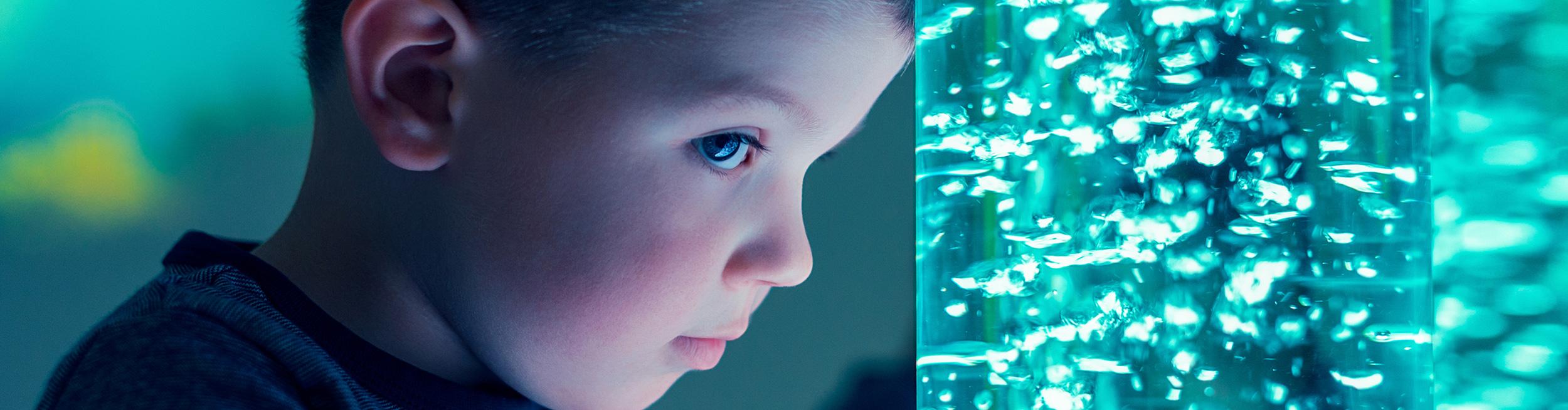 A boy looking at some sensory equipment